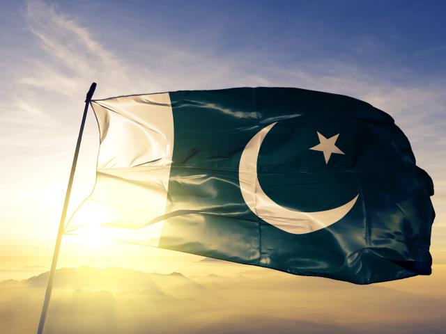 Pakistan flag with sun behind it